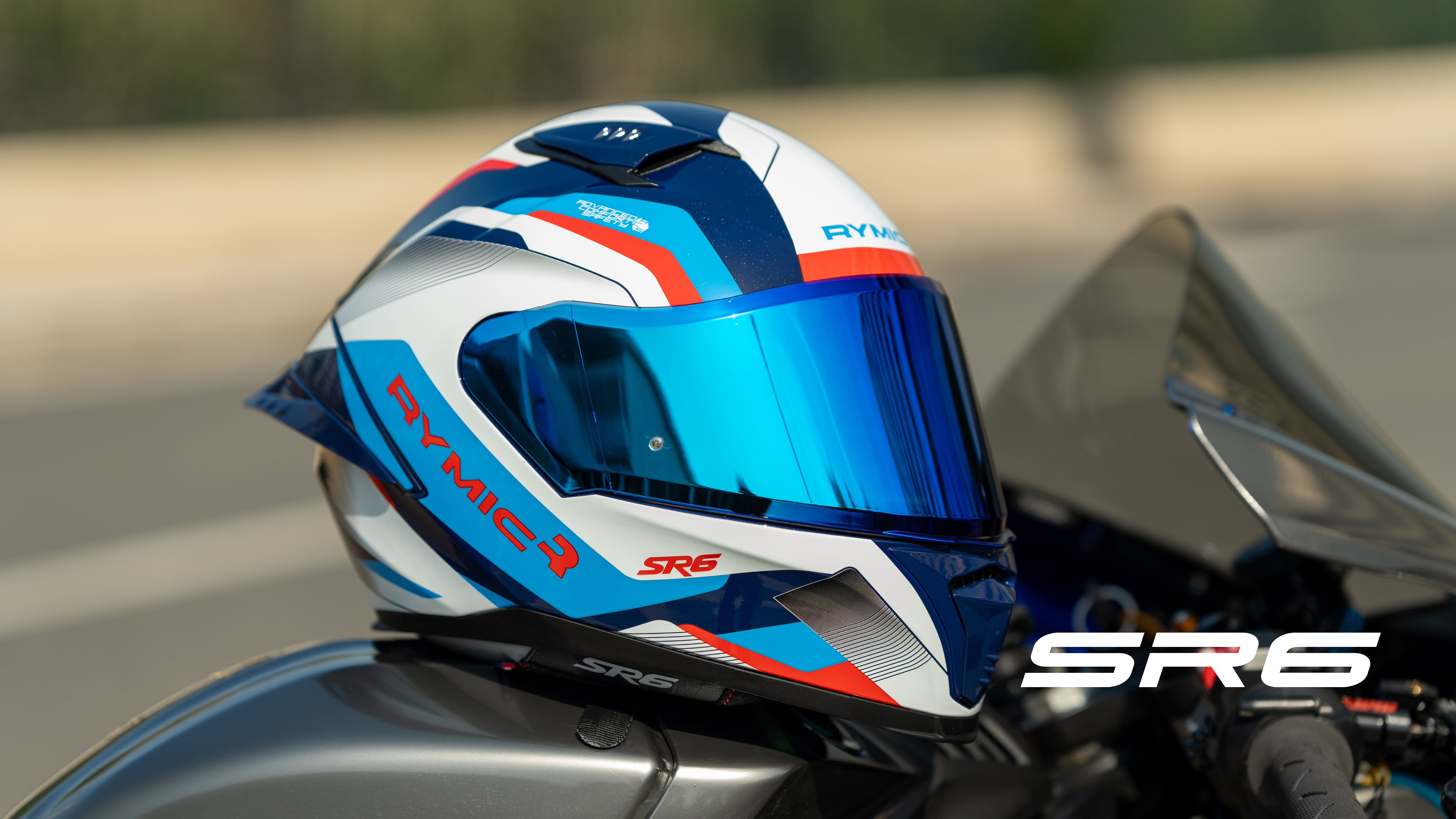 The RYMIC sr6 white & blue full face helmet is shown on the motorcycle.