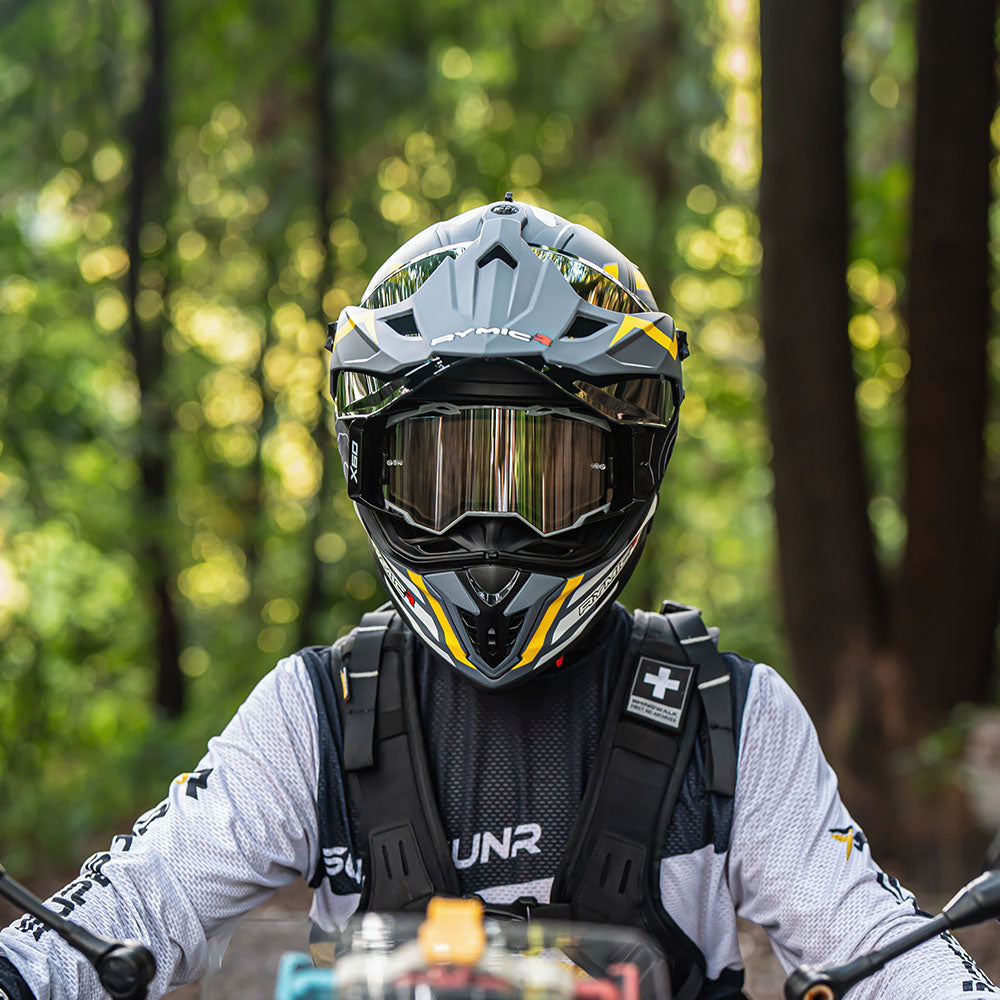 An adventurer wearing the X60 dual-sport helmet in onyx gold, ready for touring.